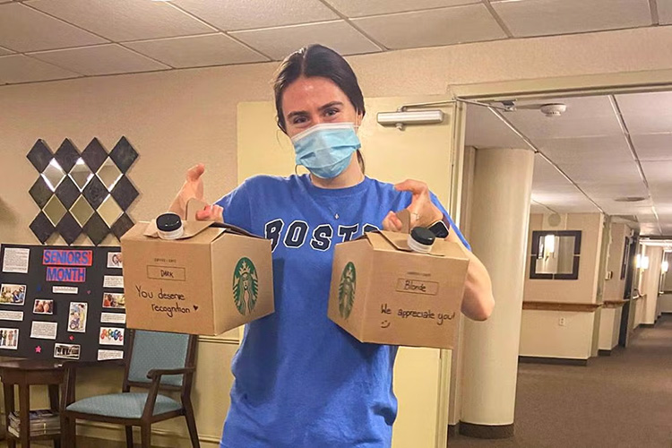 Photo of student holding coffee carriers